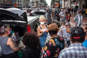 Lex Lindell, center, of New Orleans, hands out food and supplies to Hurricane Laura evacuees