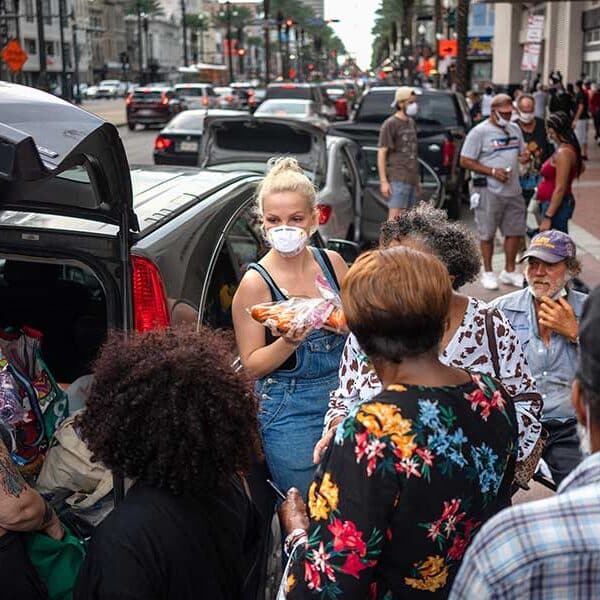 Lex Lindell, center, of New Orleans, hands out food and supplies to Hurricane Laura evacuees