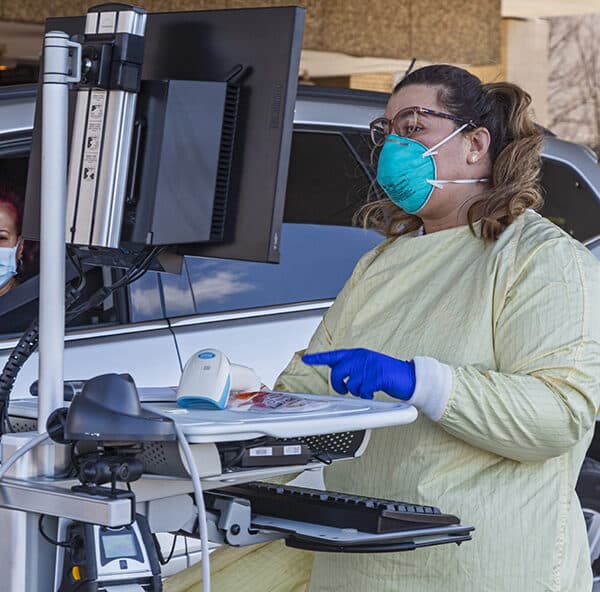 A health care worker in Royal Oak, Mich., tests for the coronavirus