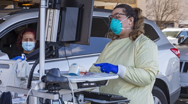 A health care worker in Royal Oak, Mich., tests for the coronavirus