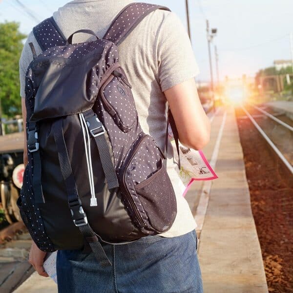 person with a backpack shown from behind with sunburst ahead