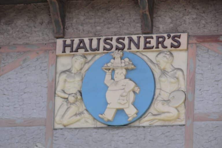 Sculpture relief with Haussner's printed on it and a man carrying a platter of food