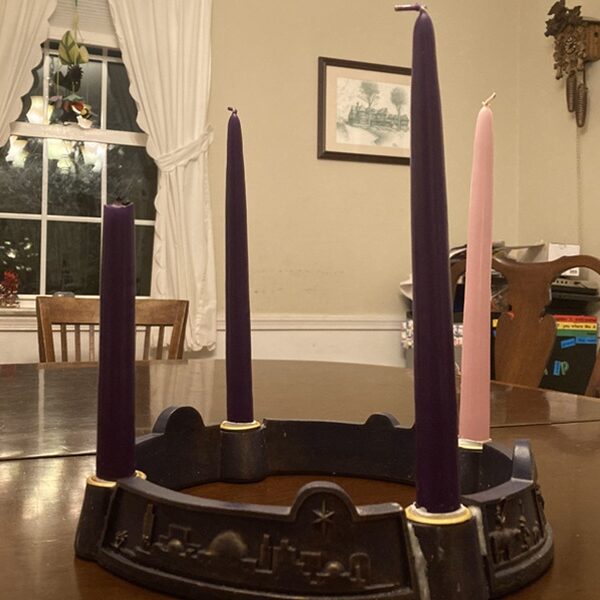Four unlit candles stand in an Advent wreath on a table