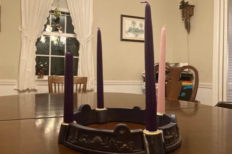 Four unlit candles stand in an Advent wreath on a table