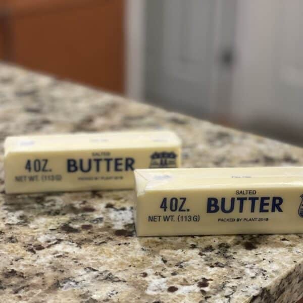 Two sticks of butter sit on a kitchen counter