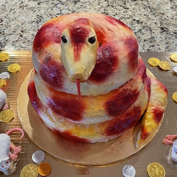 A red and gold cake in the shape of a coiled snake