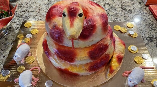 A red and gold cake in the shape of a coiled snake