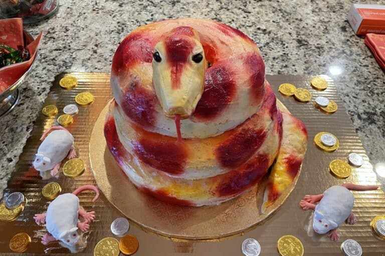 A red and gold cake in the shape of a coiled snake