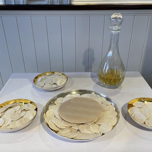 Plates of hosts and a carafe of wine on a table