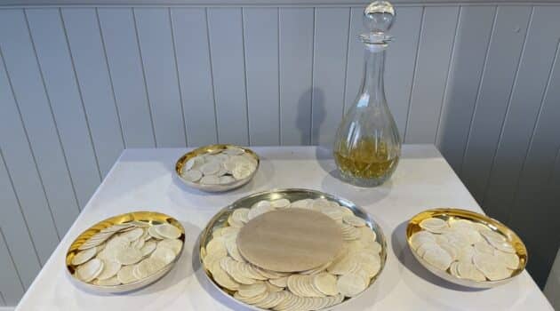 Plates of hosts and a carafe of wine on a table