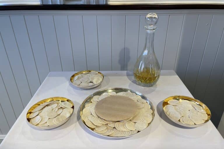 Plates of hosts and a carafe of wine on a table