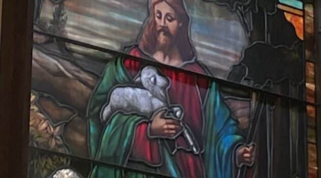 Stained glass window showing Jesus as the Good Shepherd, holding a lamb