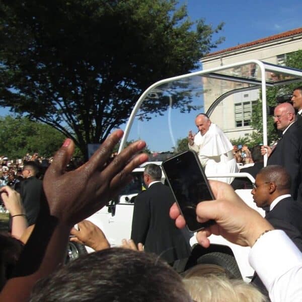 Pope Francis rides by a crowd outside Catholic University in 2015