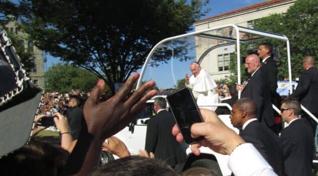 Pope Francis rides by a crowd outside Catholic University in 2015