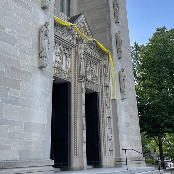 Yellow and white cloth hangs over the doors of Cathedral of Mary Our Queen in honor of the papal election