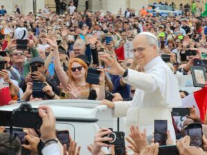 A smiling Pope Leo waves to a crowd in St. Peter's Square