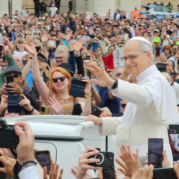 A smiling Pope Leo waves to a crowd in St. Peter's Square