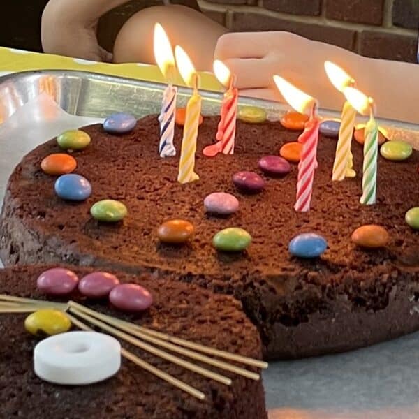 Six lit candles on a chocolate birthday cake