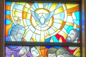 Stained glass window depicting a dove and some of the apostles with flames over their heads