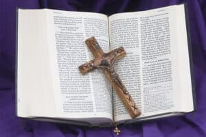 A crucifix and Bible on purple cloth