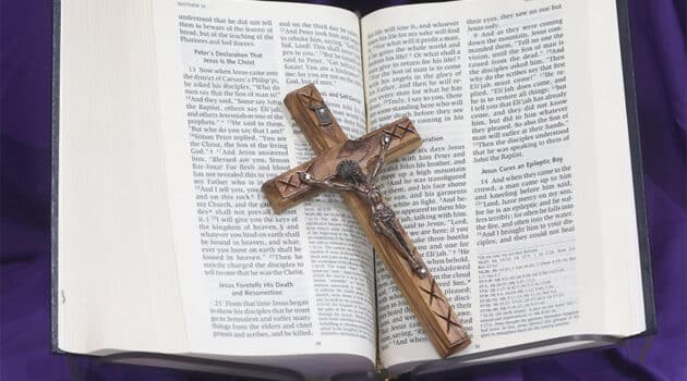 A crucifix and Bible on purple cloth