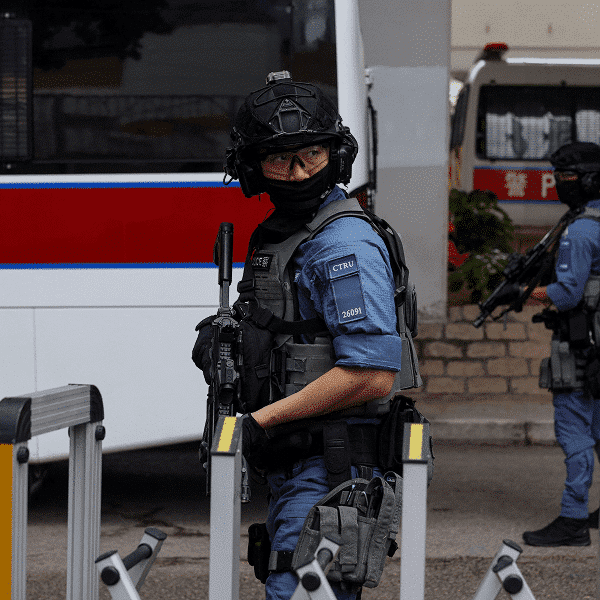 Police officers stand guard outside Jimmy Lai trial