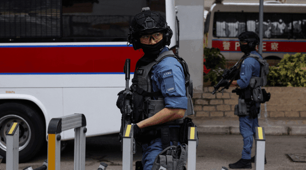 Police officers stand guard outside Jimmy Lai trial