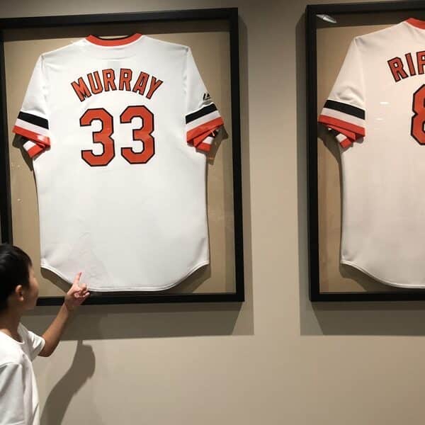 Child points to Murray and Ripken jerseys framed on the wall