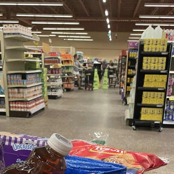Grocery store with caution signs in the background where a spill is being cleaned up
