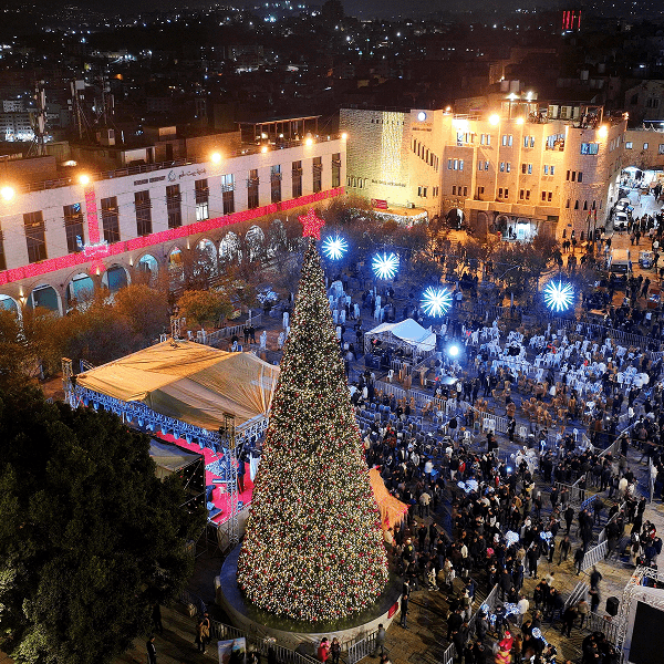 Palestinians attending a Christmas tree lighting in Manger Square outside the Church of the Nativity in Bethlehem
