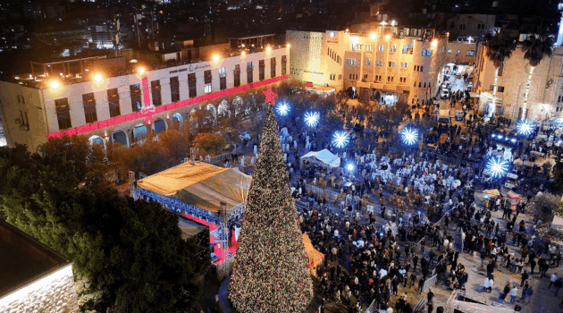 Palestinians attending a Christmas tree lighting in Manger Square outside the Church of the Nativity in Bethlehem