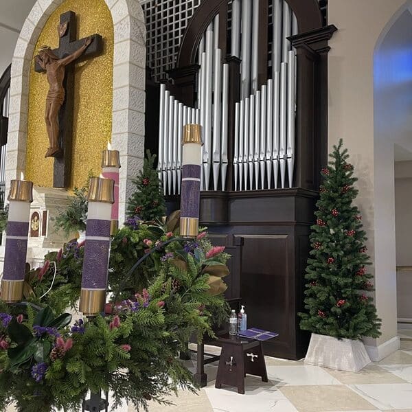 Four candles lit on Advent wreath on the altar in a church