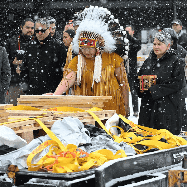 National Chief of the Assembly of First Nations Cindy Woodhouse Nepinak places her hand on Indigenous and cultural artifacts