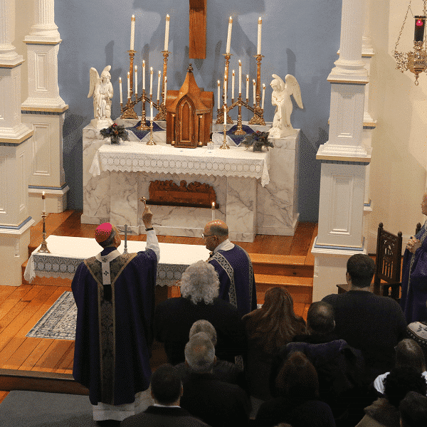 Archbishop William E. Lori sprinkles holy water on the restored historic church at St. Joseph on Carrollton Manor