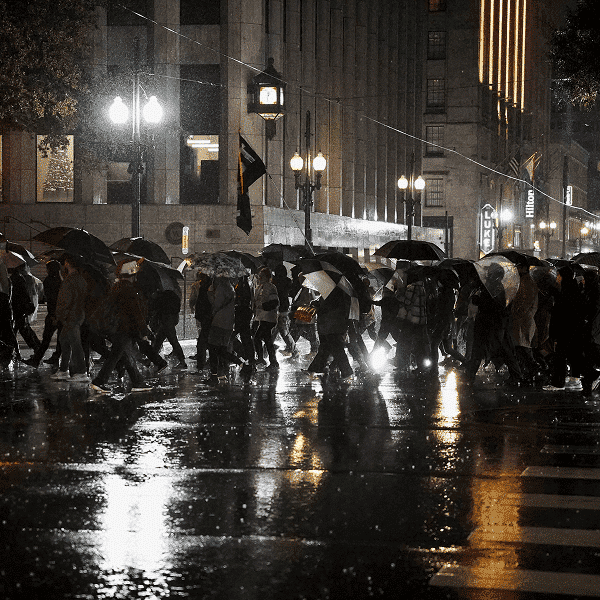 People holding umbrellas in the rain attend a protest against U.S. Immigration and Customs Enforcement