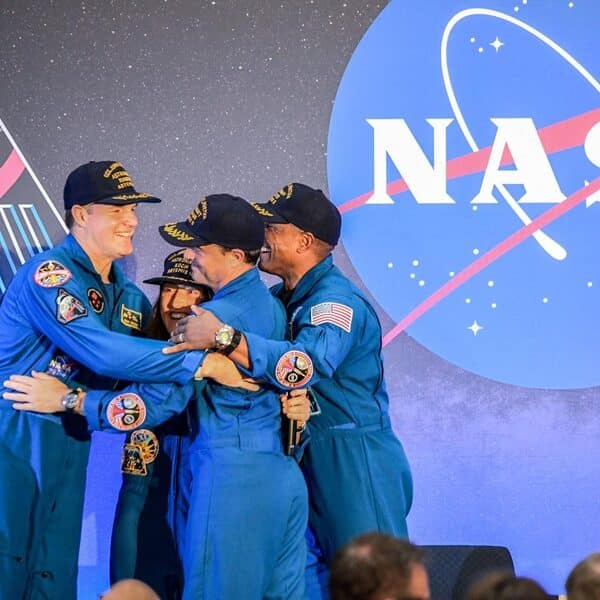 The four astronauts hug after returning from their trip on Artemis II