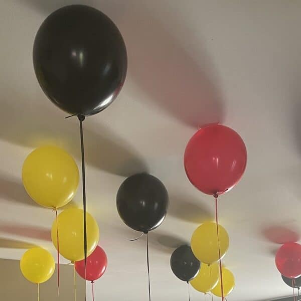 Red, yellow, and black balloons at the ceiling