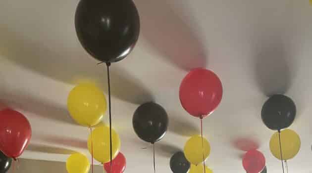Red, yellow, and black balloons at the ceiling