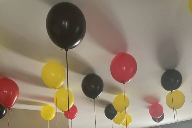 Red, yellow, and black balloons at the ceiling