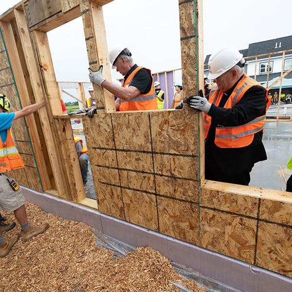 Donning hardhats, Archbishop Hebda, students help raise wall for Pope Leo Village in St. Paul