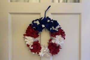 Red, white, and blue wreath hanging on a white door