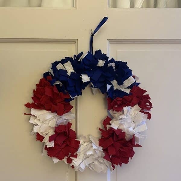 Red, white, and blue wreath hanging on a white door
