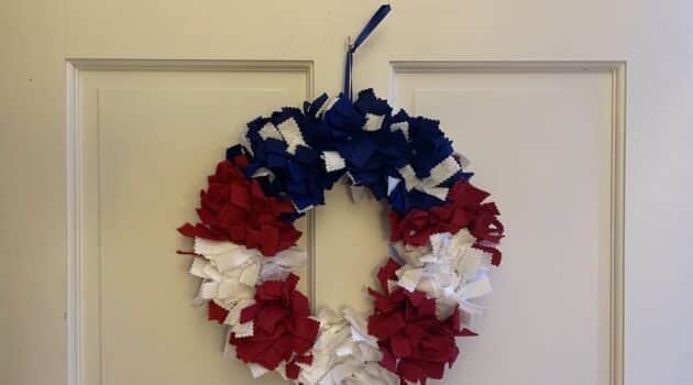 Red, white, and blue wreath hanging on a white door