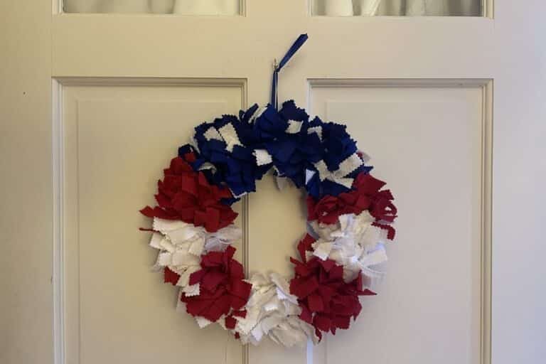 Red, white, and blue wreath hanging on a white door
